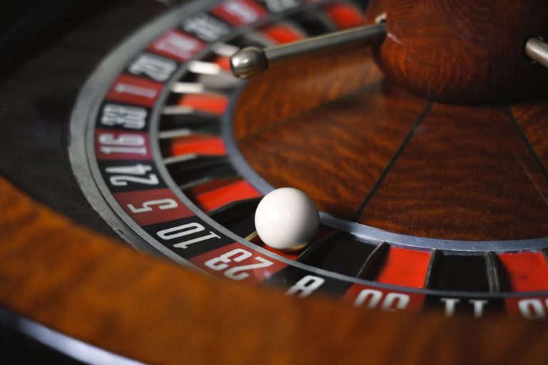 Roulette wheel with a small white ball resting in one of the numbered pockets.