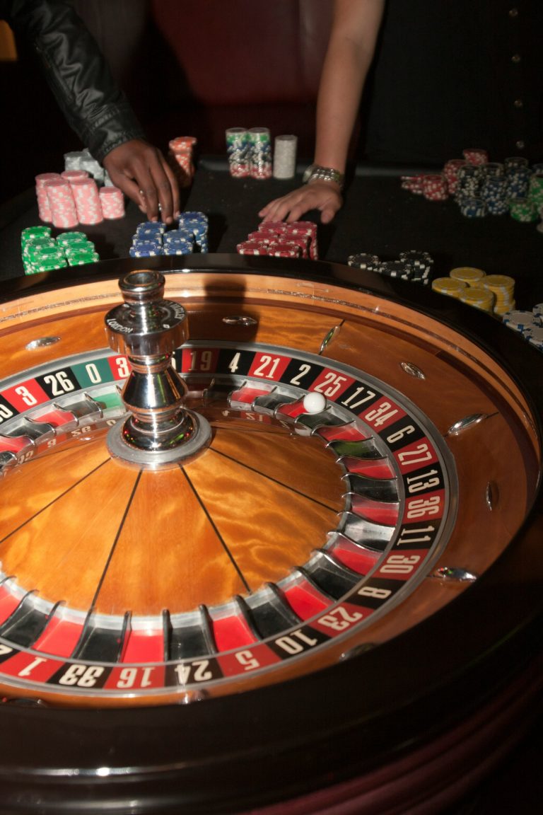 A roulette wheel spinning with several casino chips placed on the betting table.